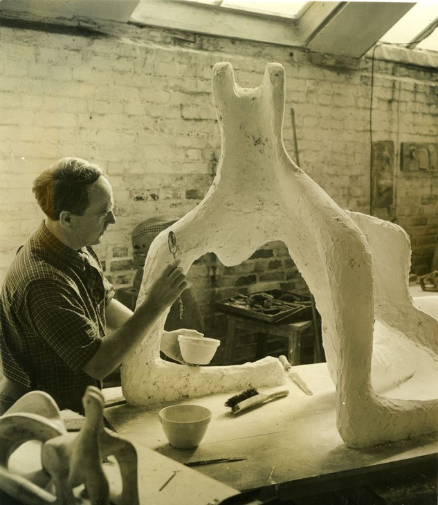 Photograph of Henry Moore working on the plaster for Reclining Figure 1951