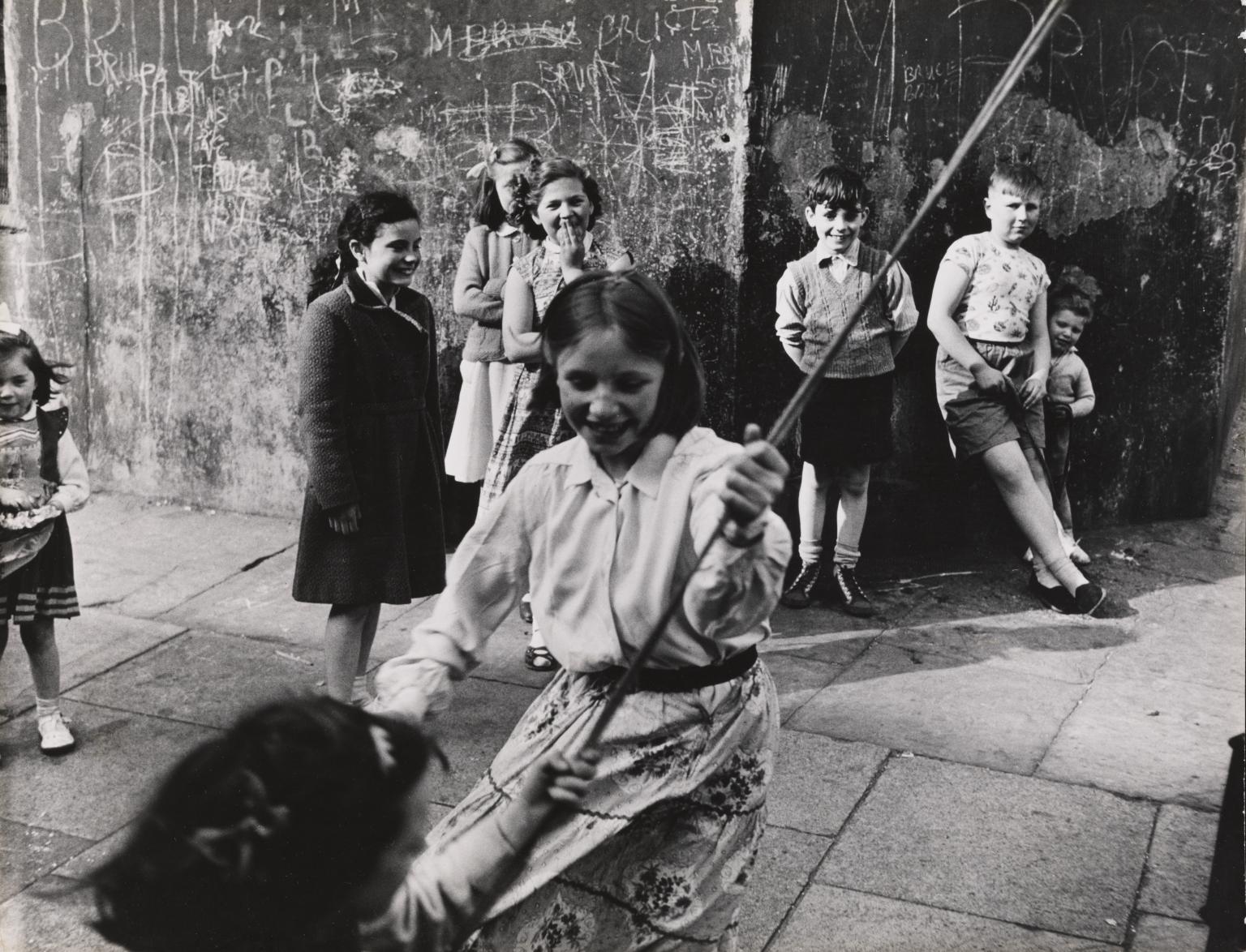 P81000: Girls swinging on a rope, Southam Street