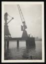Prunella Clough, ‘Black and white photograph of cranes by a dock or canal’ [1950s]