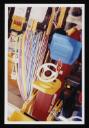 Prunella Clough, ‘Colour photograph of plastic hoops and a toy digger hanging up outside a shop’ [1990s]