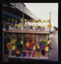 Prunella Clough, ‘Colour photograph of a stall called ‘The Tool Shed’ selling plastic buckets and spades’ [1990s]