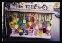 Prunella Clough, ‘Colour photograph of a stall called ‘The Tool Shed’ selling plastic buckets and spades’ [1990s]