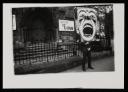 Anonymous, ‘Black and white photograph of Dougie Thomson holding a large clown placard outside a church in Glasgow’ [c.1978]