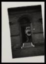 Anonymous, ‘Black and white photograph of Dougie Thomson holding a large clown placard in a doorway to a building in Glasgow’ [c.1978]