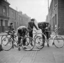 Nigel Henderson, ‘Photograph of four unidentified boys adjusting bicycles’ [c.1949–c.1956]