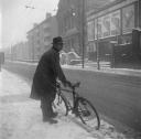 Nigel Henderson, ‘Photograph of an unidentified man with a bicycle, snow on ground’ [1953]