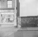 Nigel Henderson, ‘Photograph of a dog outside a shop front’ [c.1949–c.1956]
