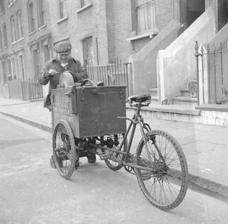 Photograph showing a knife grinder sharpening a knife on his cart', Nigel  Henderson, [c.1949–c.1956]', Nigel Henderson, [c.1949–c.1956] – Tate  Archive