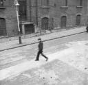 Nigel Henderson, ‘Photograph showing a man crossing Bunsen Street in Bethnal Green, London’ 1950