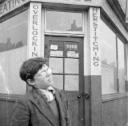 Nigel Henderson, ‘Photograph of Peter Samuels outside a tailor shop’ [c.1951]