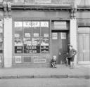 Nigel Henderson, ‘Photograph of Peter Samuels and Jo Henderson outside a shop on Roman Road, Hackney, London’ [c.1951]
