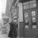 Nigel Henderson, ‘Photograph of an unidentified man in uniform outside a shop’ [c.1949–c.1956]