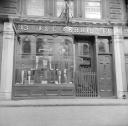 Nigel Henderson, ‘Photograph showing shop front of J. & E. Ferris, opticians’ [c.1949–c.1956]