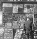 Nigel Henderson, ‘Photograph of an unidentified man looking into the window of S. Lavner, newsagents and tobacconist’ [c.1949–c.1956]
