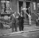 Nigel Henderson, ‘Photograph of two unidentified men in front of house decorated with bunting to mark the Coronation’ [1953]