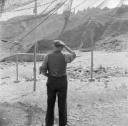 Nigel Henderson, ‘Photograph showing an unidentified man in front of hanging fishing nets’ [c.1949–c.1956]