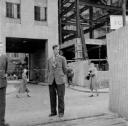 Nigel Henderson, ‘Photograph showing an unidentified man, a building under construction in background’ [c.1949–c.1956]