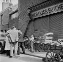 Nigel Henderson, ‘Photograph showing unidentified men and children outside a butchers’ [c.1949–c.1956]