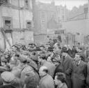 Nigel Henderson, ‘Photograph showing a crowd of men outside a derelict building’ [c.1949–c.1956]
