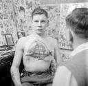 Nigel Henderson, ‘Photograph showing an unidentified man in a tattoo parlour’ [c.1949–c.1956]