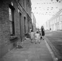 Nigel Henderson, ‘Photograph showing children playing in the street, decorated with bunting to mark the Coronation’ [1953]
