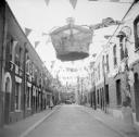 Nigel Henderson, ‘Photograph showing an unidentified street decorated with bunting and large crown to mark the Coronation’ [1953]