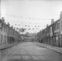 Nigel Henderson, ‘Photograph showing an unidentified street decorated with bunting and flags to mark the Coronation’ [1953]