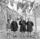 Nigel Henderson, ‘Photograph showing four unidentified children on a street decorated with bunting to mark the Coronation’ [1953]