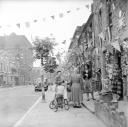 Nigel Henderson, ‘Photograph showing woman and children in an unidentified street decorated with bunting to mark the Coronation’ [1953]