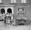 Nigel Henderson, ‘Photograph showing adults and children standing outside a house decorated to mark the Coronation’ [1953]