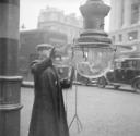 Nigel Henderson, ‘Photograph showing an unidentified man lighting a gas street lamp’ [c.1949–c.1956]