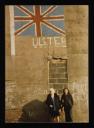 Conrad Atkinson, ‘Colour photograph, mounted on board, of two women standing in front of a wall with a Union Jack and the word, ‘Ulster’, painted on it.’ [c.1975]