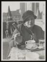 Unknown Photographer, ‘Photograph of Henriette von Motesiczky sitting at a table with a cup of coffee and holding a roll in her hand’ [c.1910–20s]