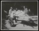Unknown Photographer, ‘Photograph of Henriette von Motesiczky lying down on bench with two dogs at her feet, and two people sitting at table behind her’ [c.1920s]