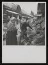 Unknown Photographer, ‘Photograph of Henriette von Motesiczky walking by several fruit and vegetable market stalls’ [c.1950s]
