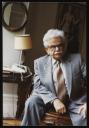 Marie-Louise Von Motesiczky, ‘Photograph of Elias Canetti sitting in Marie-Louise von Motesiczky’s sitting room with her work ‘At the Dressmaker’ hanging on the wall behind him’ July 1983