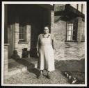 Unknown Photographer, ‘Photograph of Marie Hauptmann in an apron standing outside a house ’ [c.1940s]