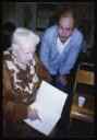 Marie-Louise Von Motesiczky, ‘Photograph of Marie-Louise von Motesiczky sitting down with an unidentified man signing a book, at her visit to a prison art class with Sheela Bonarjee on her 87th birthday’ [October 1993]