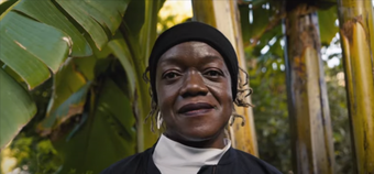 Photograph of artist Claudette Johnson standing in front of trees