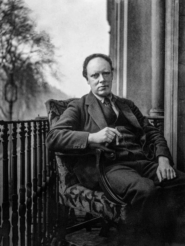 Black and white negative of Clive Bell seated by a balcony, smoking a