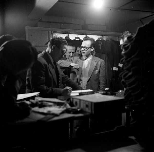 Photograph showing musicians iinside a shop selling men’s clothes
