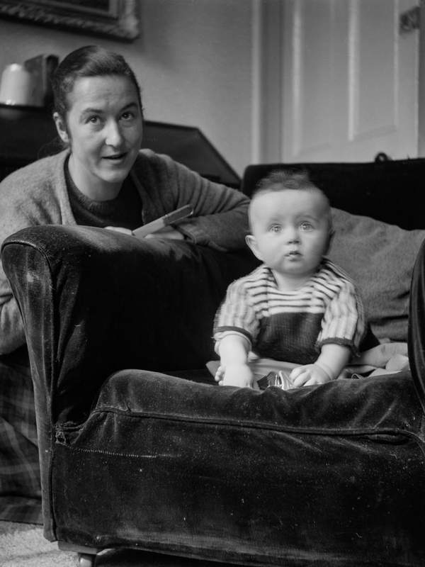 Black and white negative of Julian C. Bell seated on a velvet armchair ...