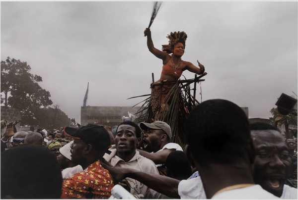 A traditional dancer and crowd salute Jean-Pierre Bemba as he makes his way to a rally from the airport, Kinshasa