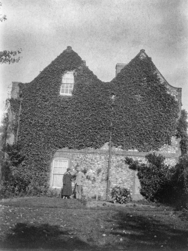 Black and white negative of two unidentified figures in front of the ...