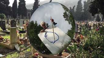 Photograph of artist Joan Jonas with a large circular mirror