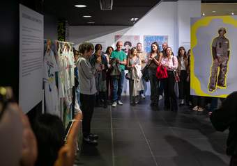 A young person standing with a microphone in front of a group