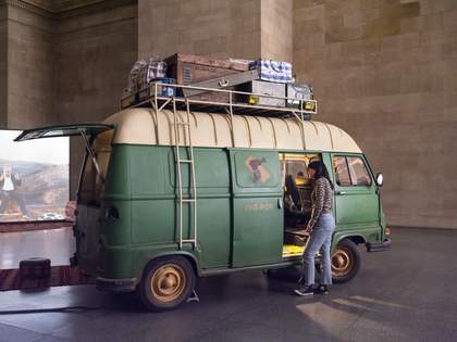 Person looking inside a green 1960s van/mobile cinema unit