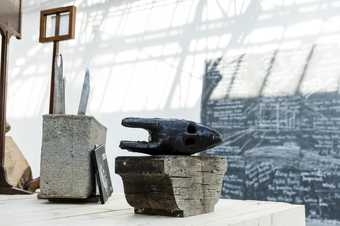 a ceramic mask sits on a plinth