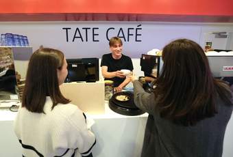 A photograph of two visitors being served at the Tate Liverpool + RIBA North cafe