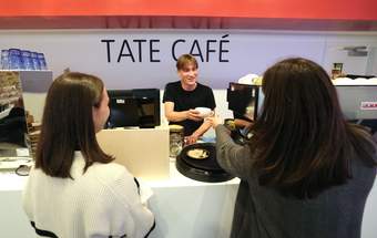A photograph of two visitors being served at the Tate Liverpool + RIBA North cafe